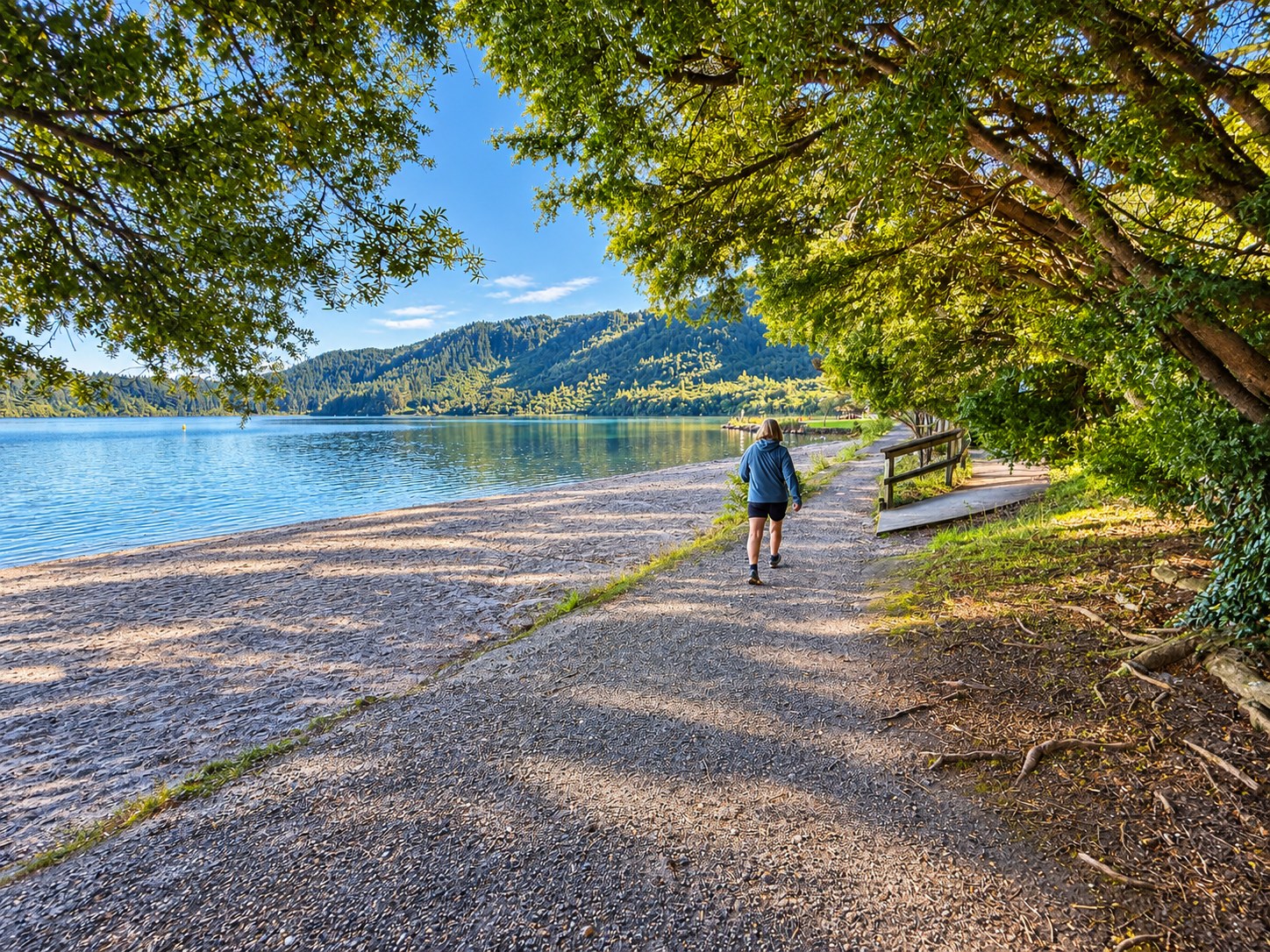 A walker following a peaceful lakeside path